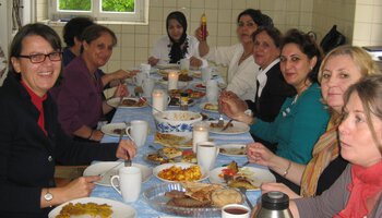 Viele Frauen sitzen zusammen an einem großen Tisch | © Caritasverband München